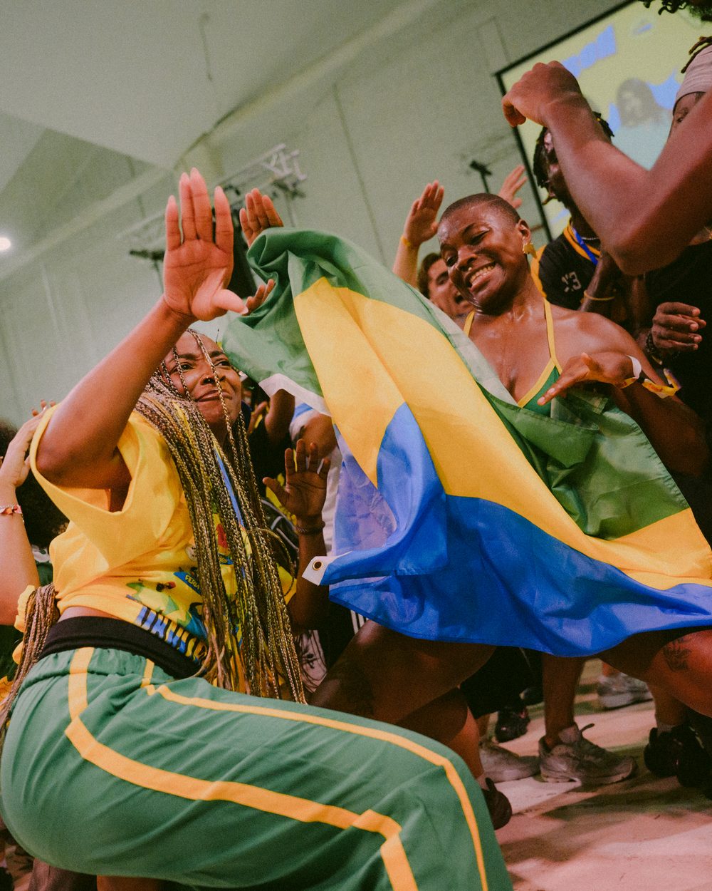 Dancers celebrating on the floor at OYOFE, one wrapped in a flag